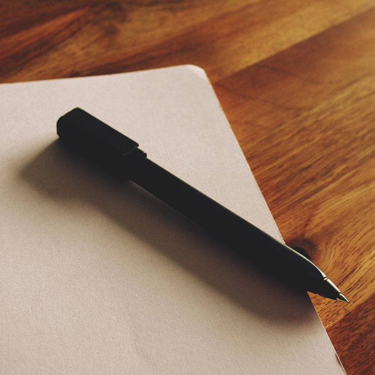 Pen lying on an open, blank notebook page