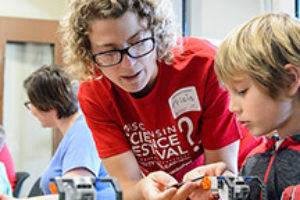 Photo of woman interacting with children at science festival by Bryce Richter from University Communications