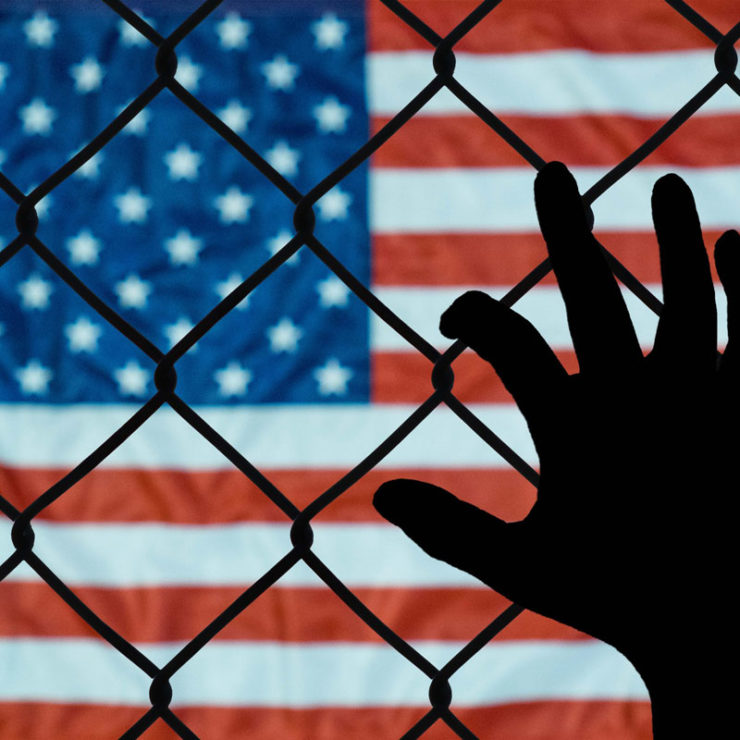 Silhouette Of Hand On Fence With American Flag In The Background To Depict Parent Child Separation At The Mexico Us Border