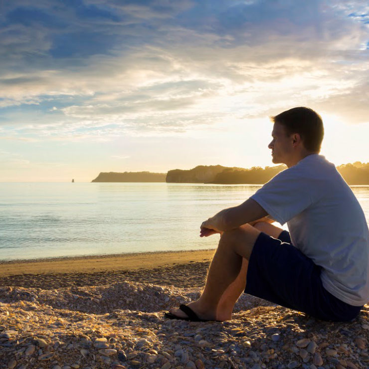 Photo of a man looking out at water via  Istock 