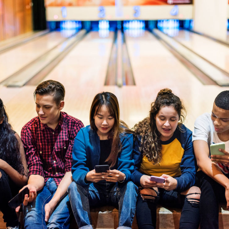Teenagers Sitting In A Bowling Alley Depicting Well Being In Adolescents