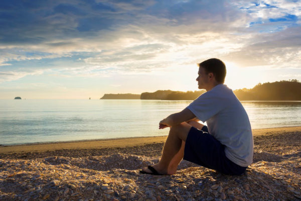 Photo of a man looking out at water via  Istock 